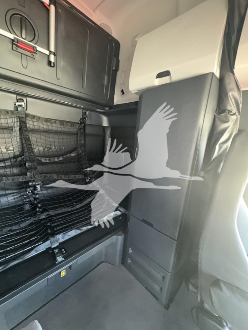 Freightliner Cascadia sleeper cab interior showing storage cabinet and cargo net in side wall area