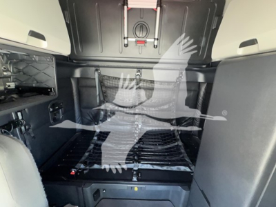 Truck cab interior of a 2023 Freightliner Cascadia 126 sleeper showing main cargo area with bed platform and wall panels. 