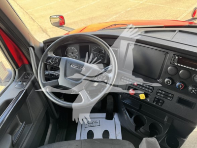 Freightliner Cascadia truck interior/dashboard with steering wheel, gauges, center console, and driver-side view.