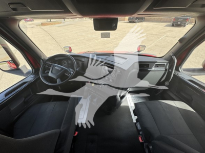 2023 Freightliner Cascadia 126 interior view showing dash, steering wheel, and front seats. faint watermark overlay of a hand with teeth logo across the image.