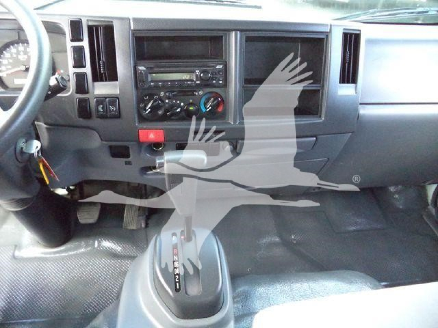 Dashboard and center console of a 2021 Isuzu NPR HD showing gear shifter, radio, climate controls, and control panel.
