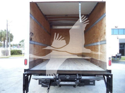 Isuzu NPR-HD box truck cargo area viewed from rear open doors showing empty wooden floor and side walls.