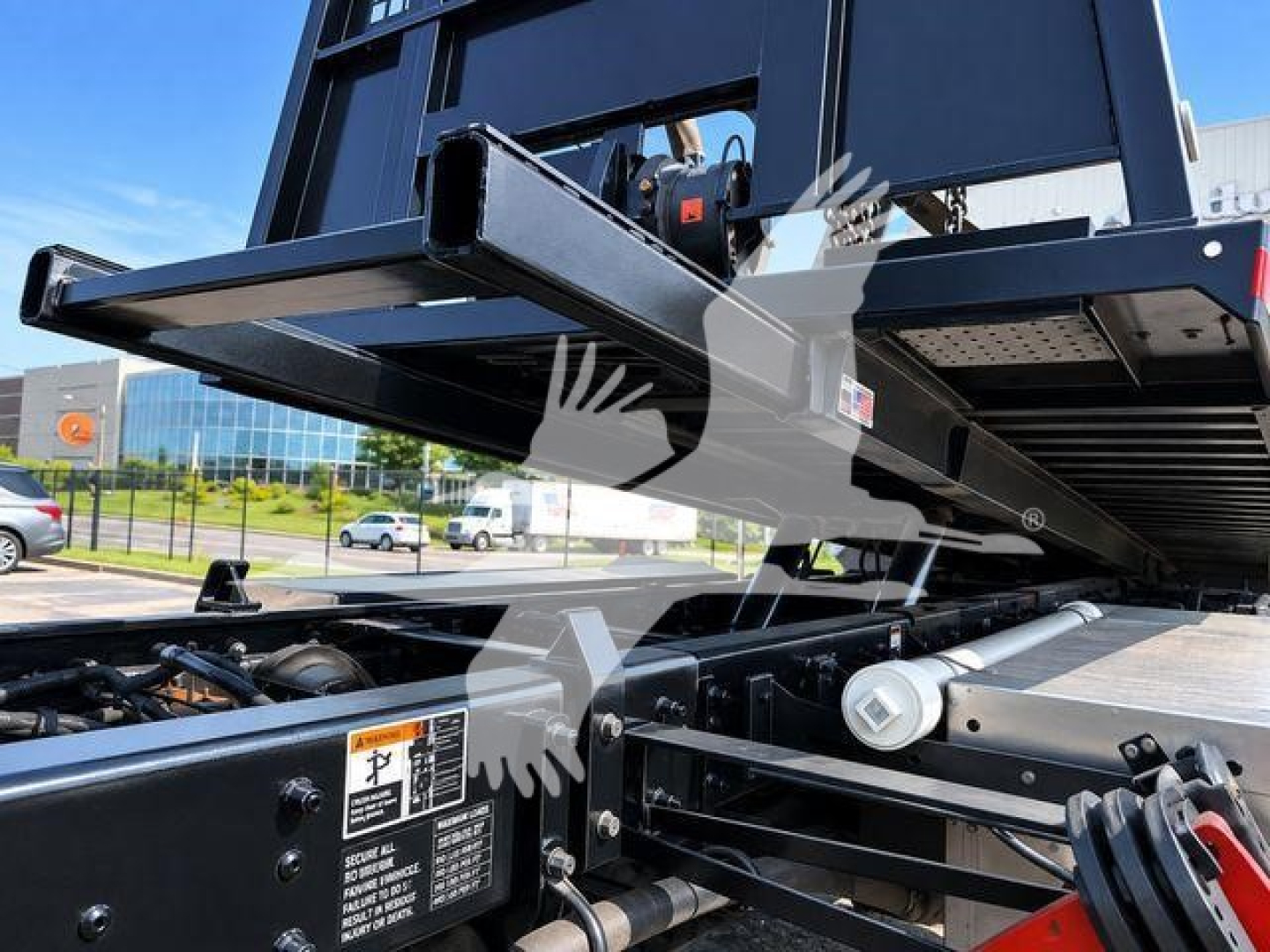 Kenworth T370 truck rollback flatbed area showing hydraulic tilt mechanism and metal frame components.