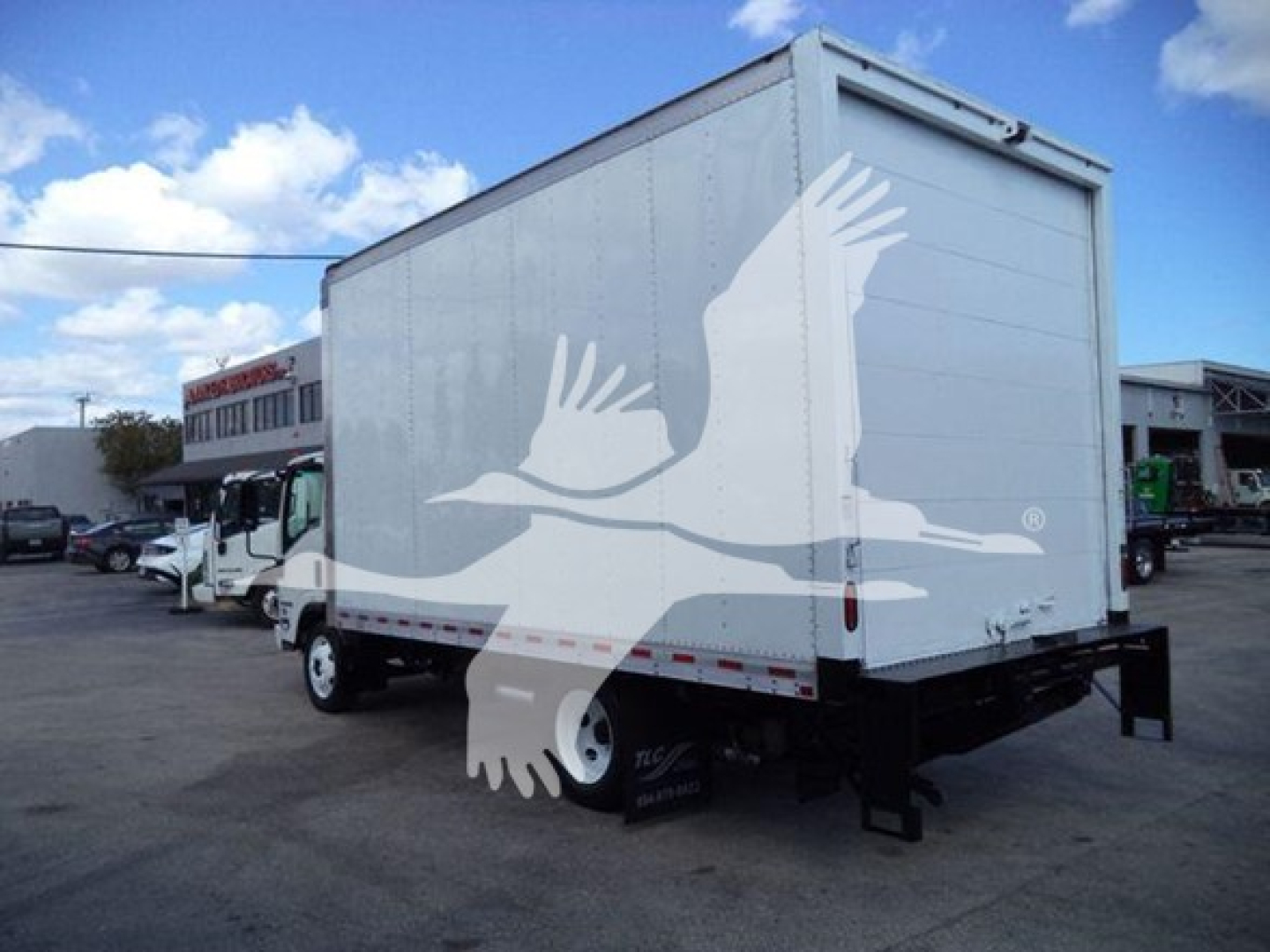 Isuzu NPR-HD box truck rear view showing white cargo box and dual rear wheels.