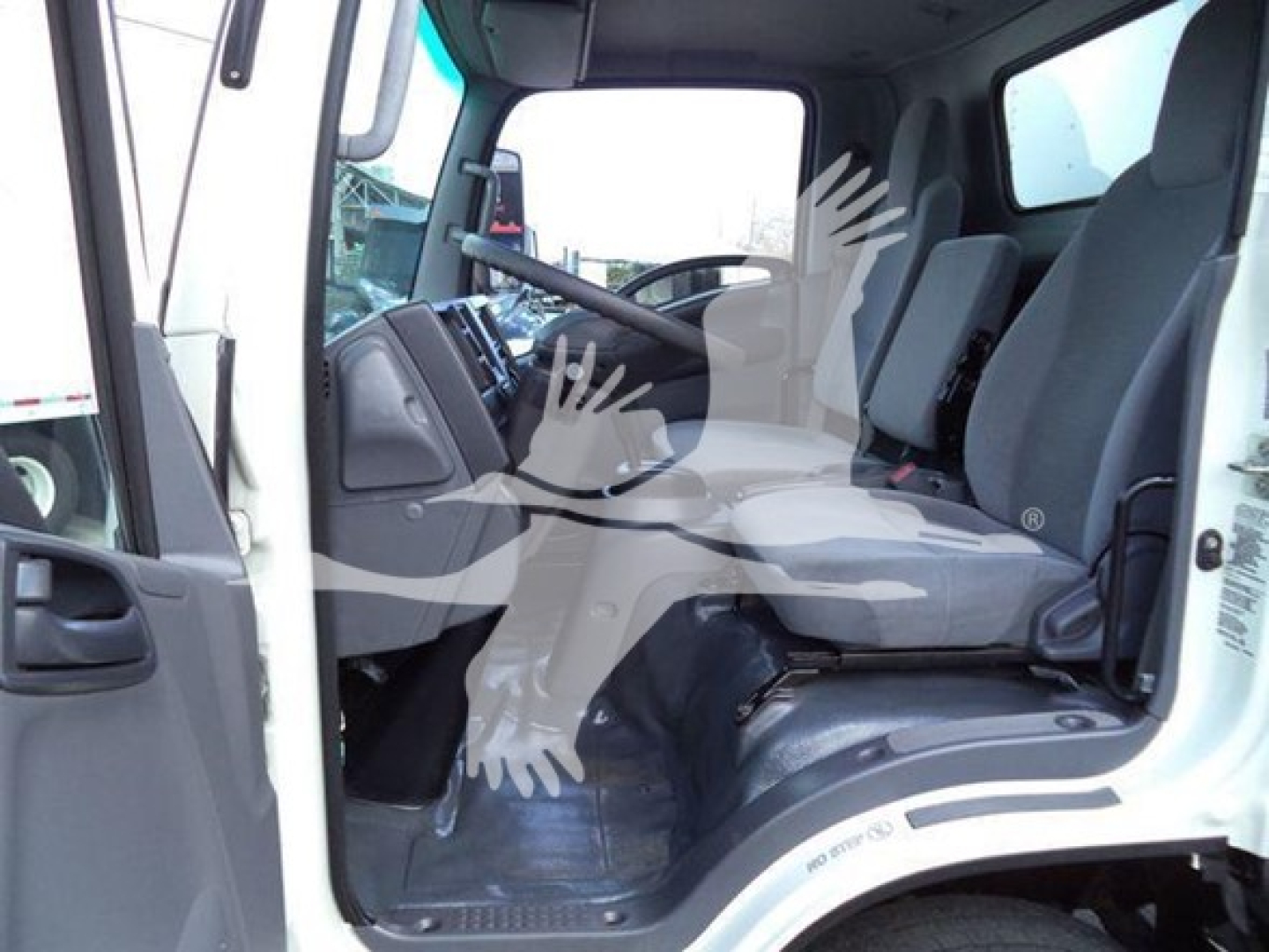Isuzu NPR HD truck interior cab view showing driver seat and passenger seat, steering wheel, dashboard, and entry area.