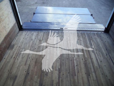 Isuzu NPR HD box truck interior floor with a white bird silhouette graphic and metal ramp at the doorway.