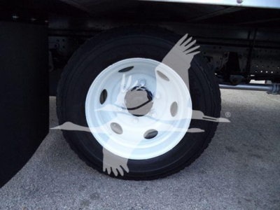 Isuzu NPR HD truck wheel with white rim and tire, undercarriage visible.