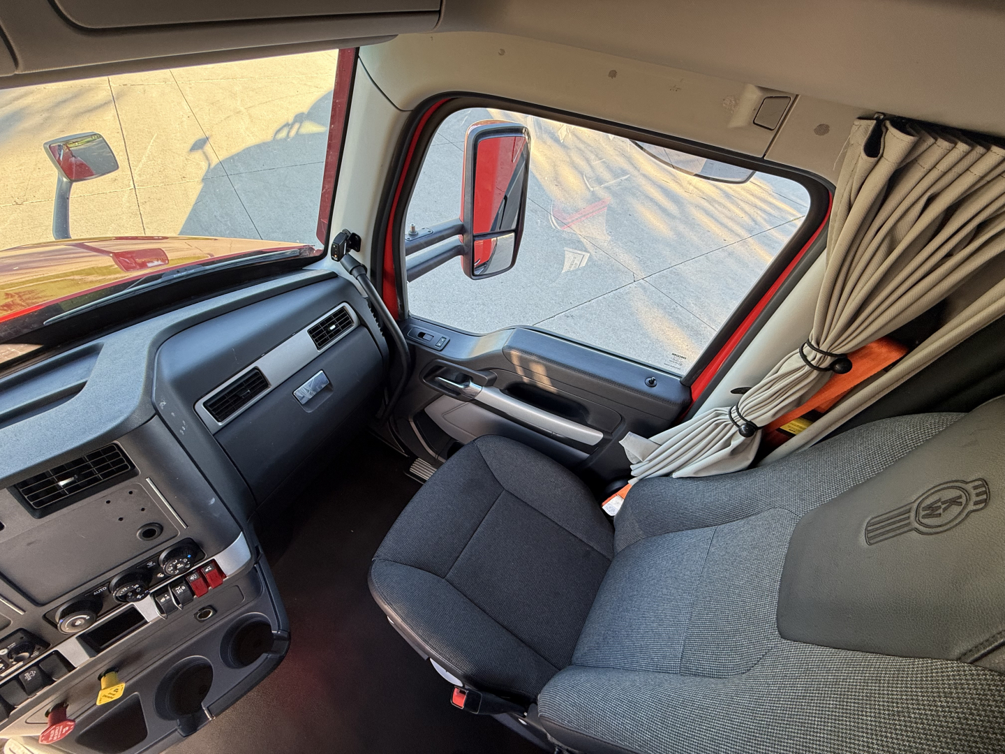 Kenworth T680 truck interior driver seat and dashboard view.