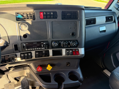 Kenworth T680 truck interior dashboard with center controls, vents, switches, and cup holders.