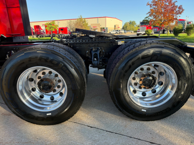 Kenworth T680 truck rear dual wheels and chassis showing two polished chrome wheels and tires with visible suspension components.
