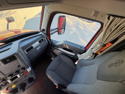 Kenworth T680 truck interior driver seat and dashboard view.