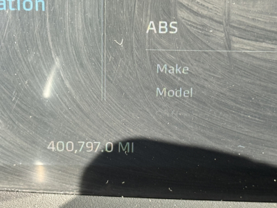 Kenworth truck dashboard display showing ABS, Make, Model, 400,797.0 MI, VIN/stock area text blurred.