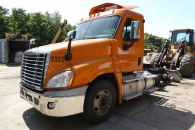Orange Freightliner Cascadia 125 daycab truck front view showing grille and cab number 33520.