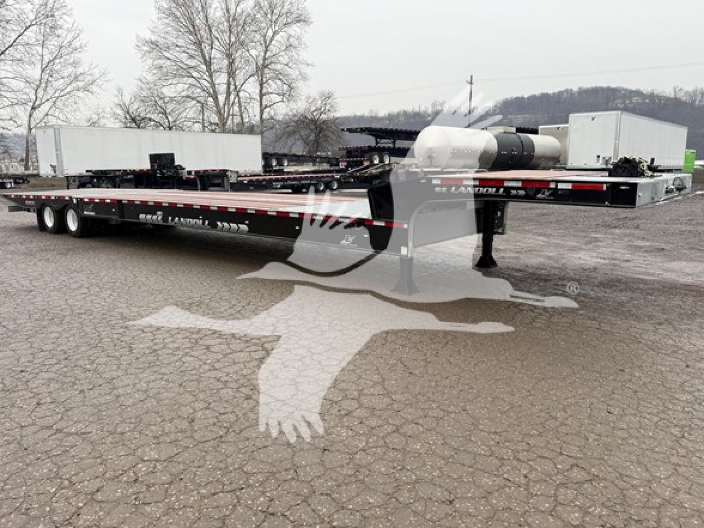Landoll 930E drop deck trailer showing deck, wheels, and rear coupler with markings and stock decals.