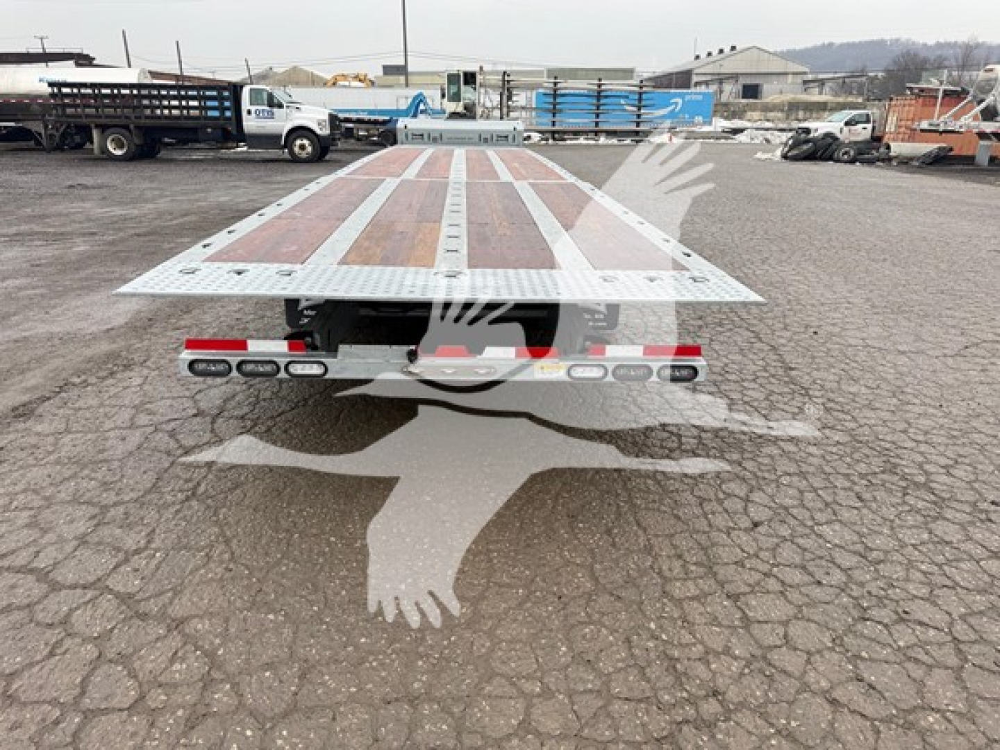 Landoll 930E drop deck trailer rear view showing wood-plank deck with metal frame and wheels beneath.