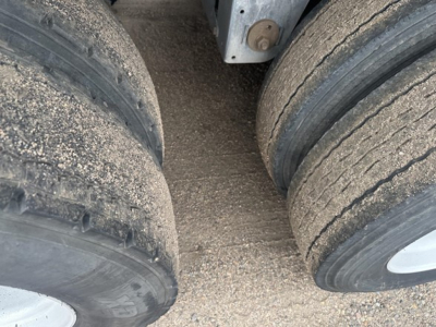 Trailer axle close-up showing dual rear tires and undercarriage of a 2017 Mac MVP frameless aluminum end dump.