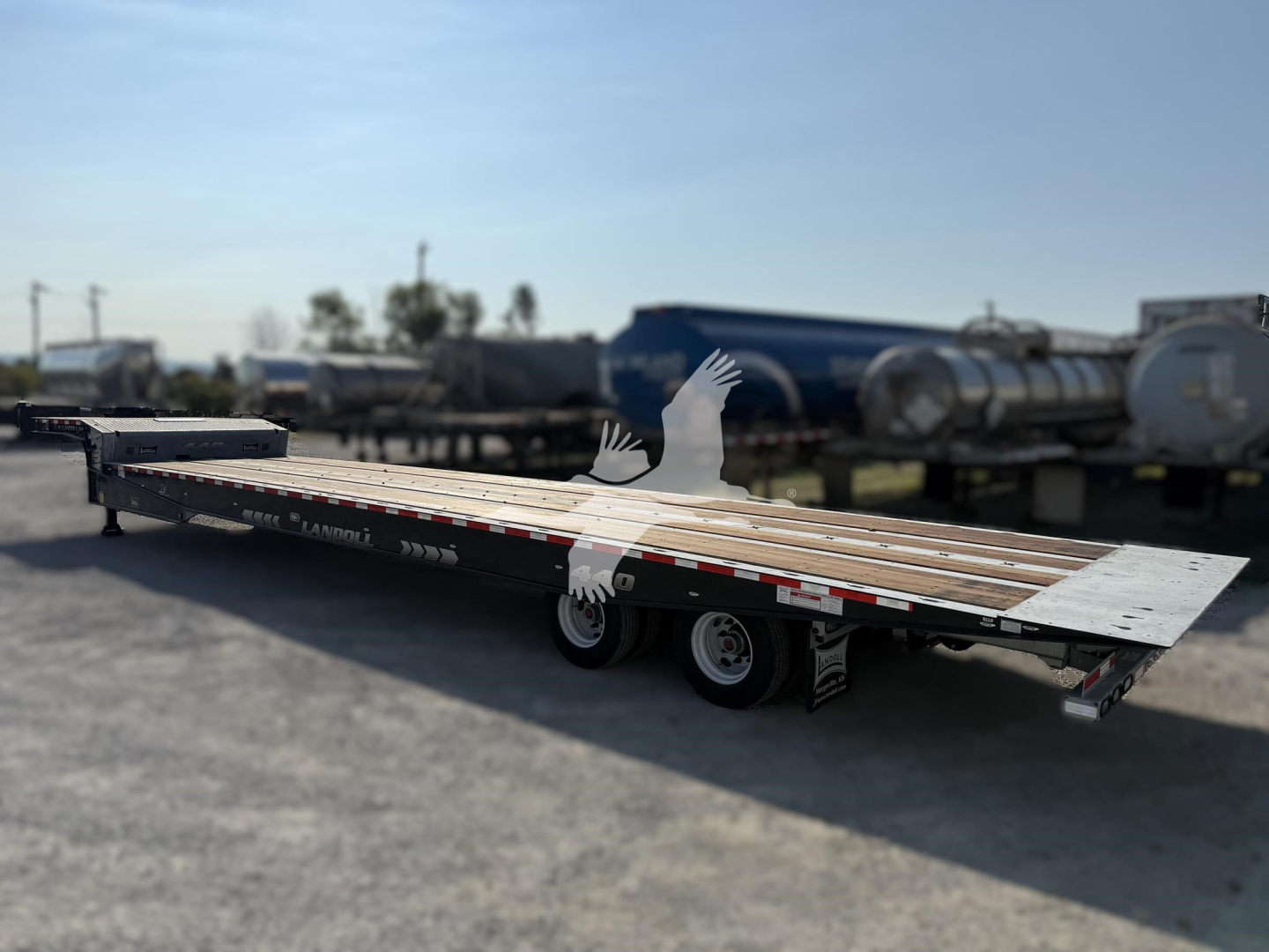 Landoll 440 traveling axle trailer in view showing long flatbed with multiple axles and wheel wells.