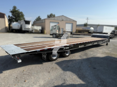 Landoll 440 trailer with long flatbed and wood deck, side rails, dual rear axles, in-yard. Visible VIN tag area and wheel hubs.