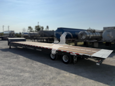 Landoll 440 traveling axle trailer in view showing long flatbed with multiple axles and wheel wells.