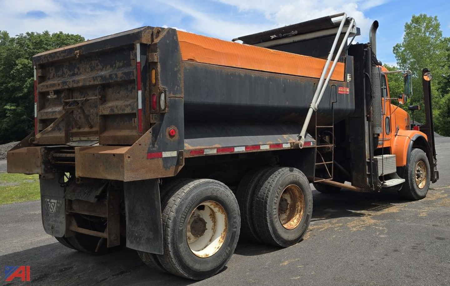 Dump truck side rear view showing dump bed and rear tires on a Freightliner FLD120 SD dump truck.