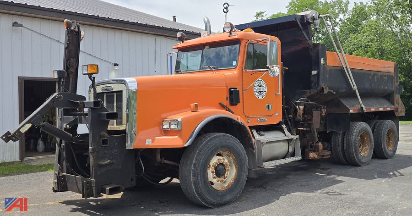 Orange 2001 Freightliner FLD120 SD dump truck front view showing snow plow attachment and dump bed side angle text not legible