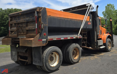 Dump truck side rear view showing dump bed and rear tires on a Freightliner FLD120 SD dump truck.