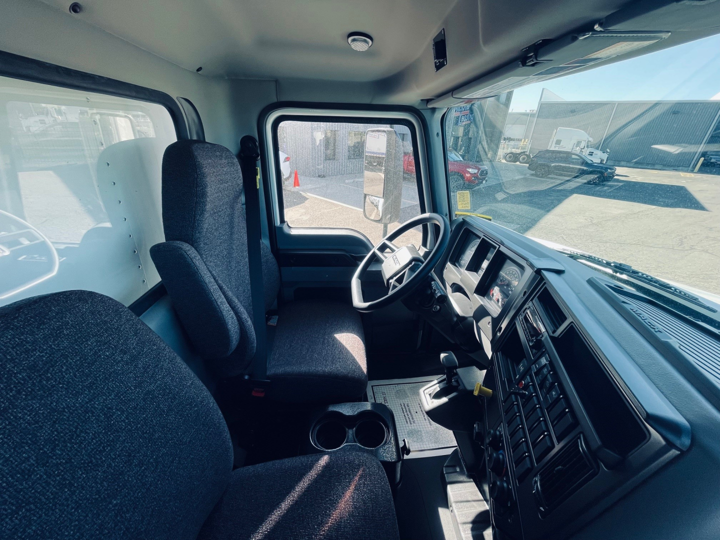 Mack MD6 cab interior showing steering wheel, driver seat, and dashboard with center console.