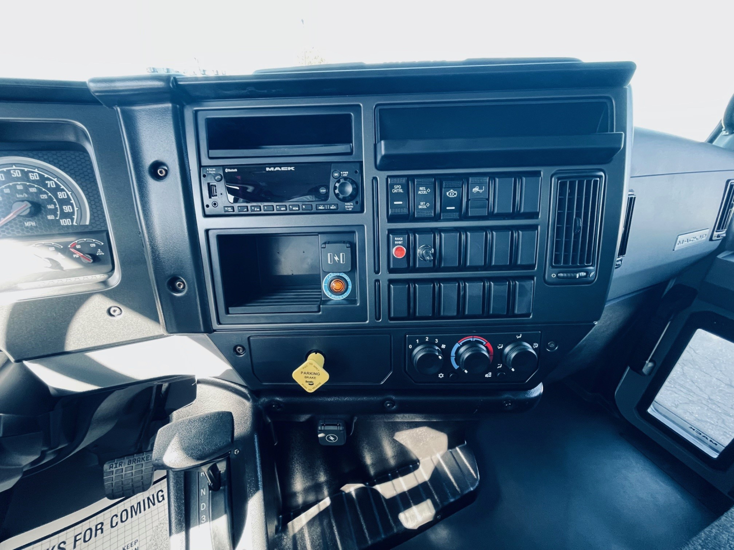 Dashboard of a 2026 Mack MD6 showing instrument cluster, radio, climate controls, and various switches. Visible text includes DASHER? not clear; average dashboard components.