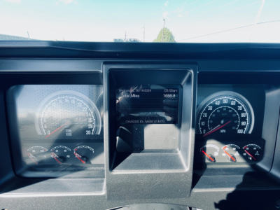 Dash cluster of a new 2026 Mack MD6 truck showing instrument gauges and a central digital display with mileage and status.