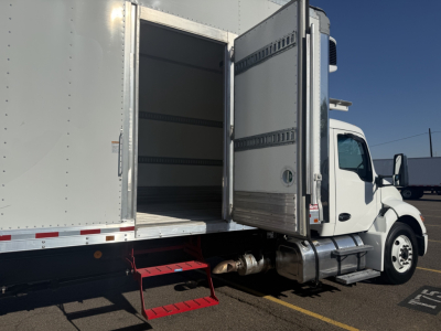 Kenworth T380 refrigerated truck side with open rear doors showing cargo area and steps.