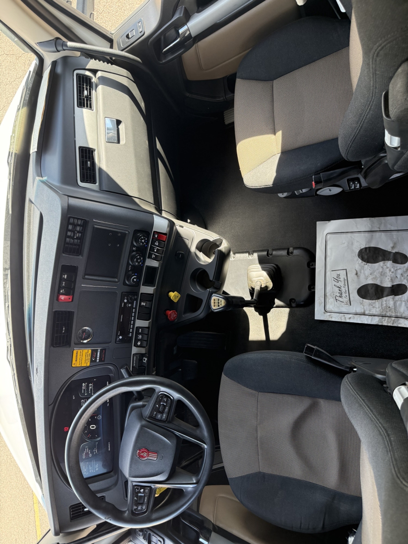 Kenworth T680 truck interior dashboard and steering wheel showing driver seat and center console.