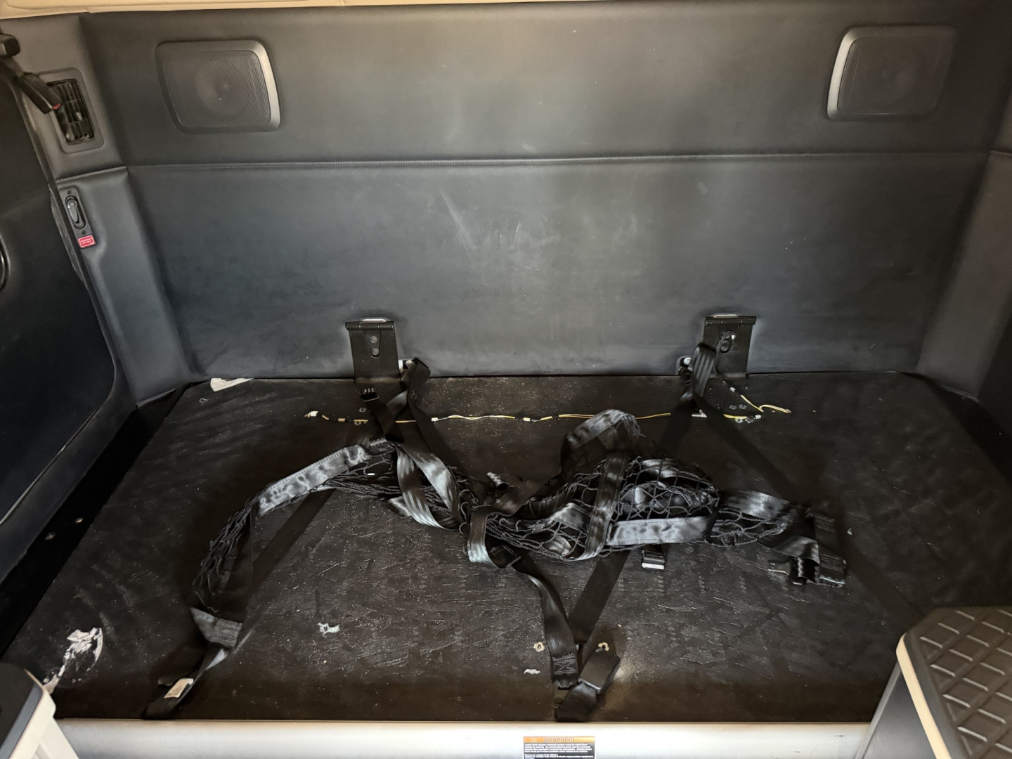 Kenworth T680 truck interior cargo area with folded seat belts and mounting brackets in rear sleeper area.