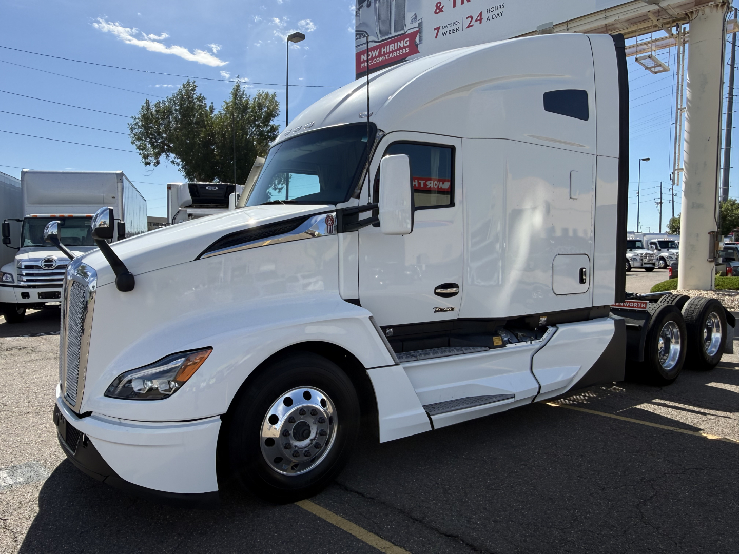 Kenworth T680 tractor trailer cab in white, side view showing windshield, mirrors, and front grille.