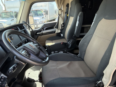 Kenworth T680 cab interior showing steering wheel, driver seat, and passenger seat in view with dashboard and center console.