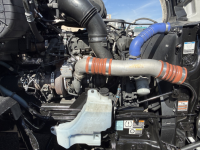 Kenworth T680 engine bay view showing air intake tubing, coolant reservoir, hoses, and turbocharger components.