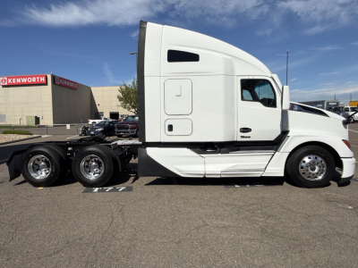Kenworth T680 sleeper tractor side view showing cab with white paint and dual rear axles.