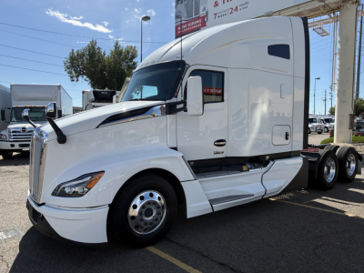 Kenworth T680 tractor trailer cab in white, side view showing windshield, mirrors, and front grille.