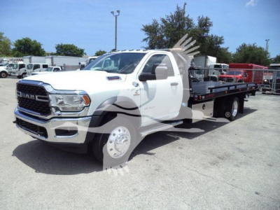 Ram 5500 rollback tow truck with white cab and black flatbed, front grille with RAM logo, text on door badge, and dealership watermark across; no legible overlay text.