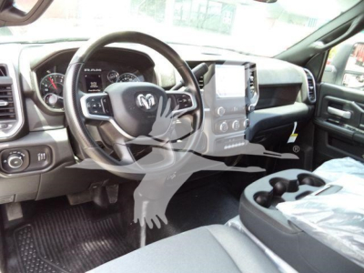 Interior view of a 2024 Ram 5500 SLT showing steering wheel with Ram logo, central touchscreen, dashboard gauges, and center console with cup holders.