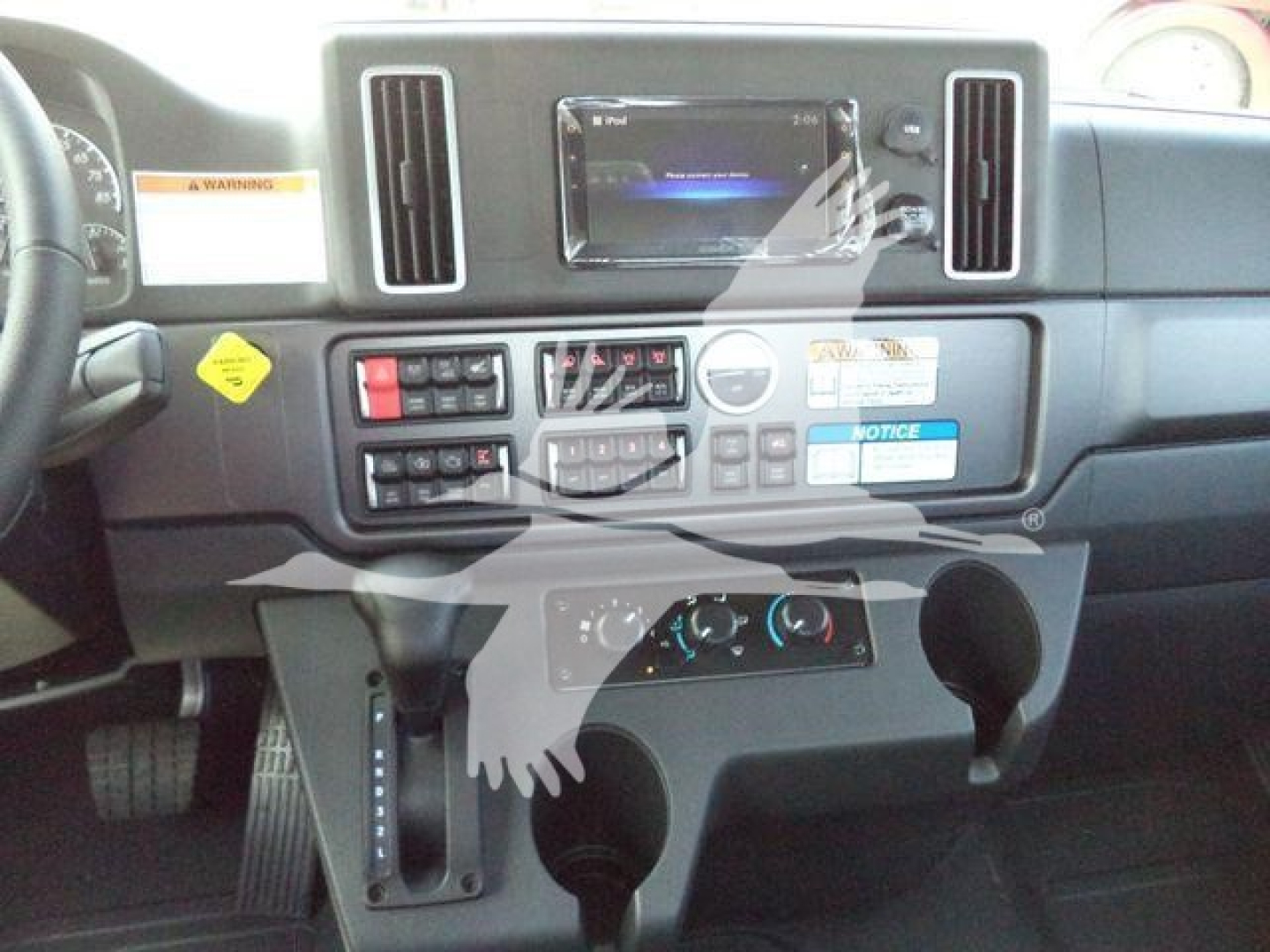 Freightliner M2 106 Plus cabin dashboard with center touchscreen, control panel, and gear lever visible.