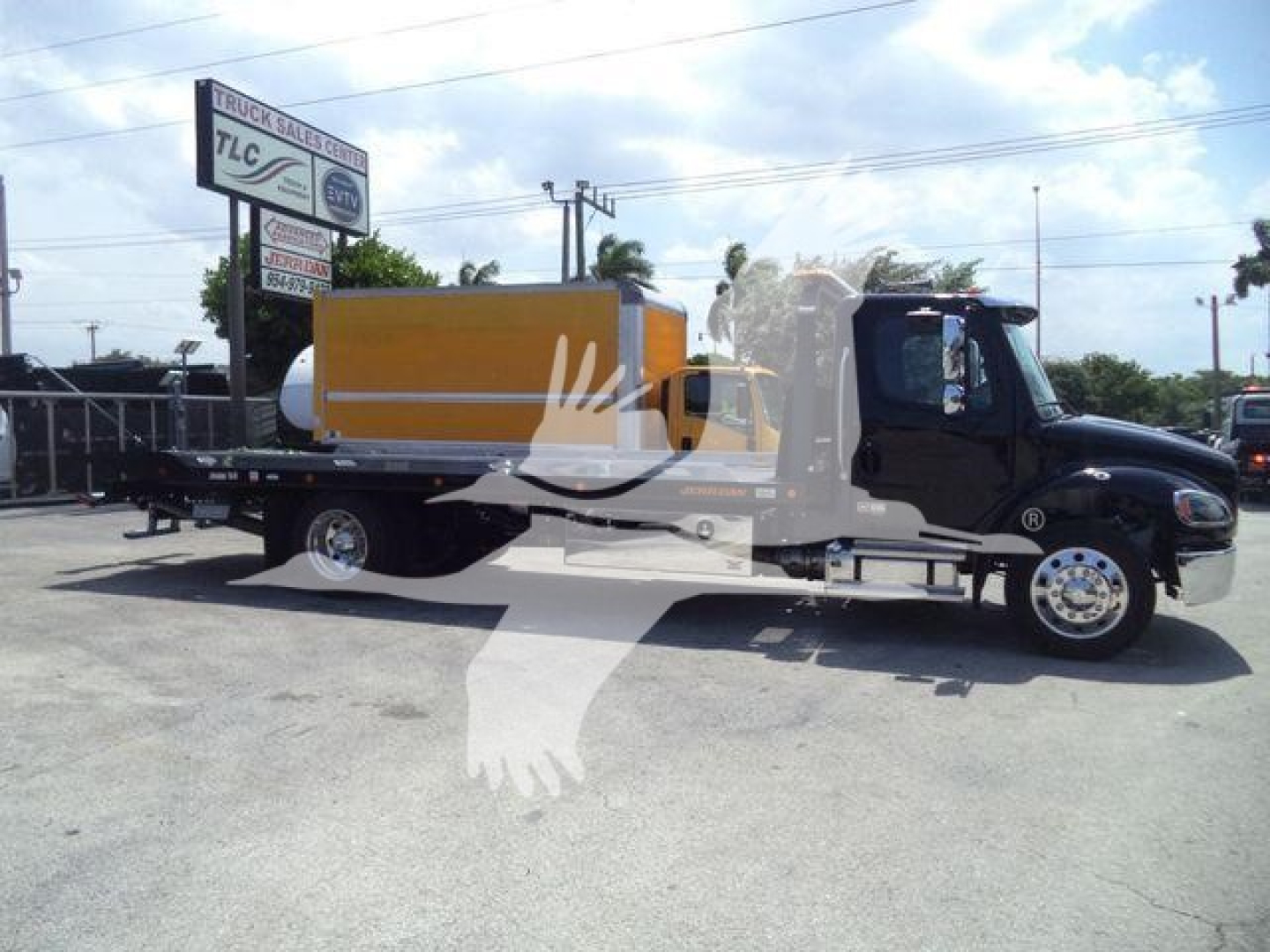 Freightliner M2 106 Plus rollback truck side view showing cab and flatbed with yellow tank