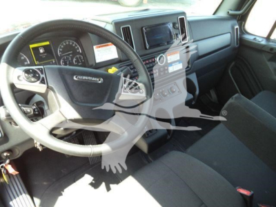 Freightliner M2 106 Plus cab interior showing steering wheel and dashboard with infotainment screen and controls