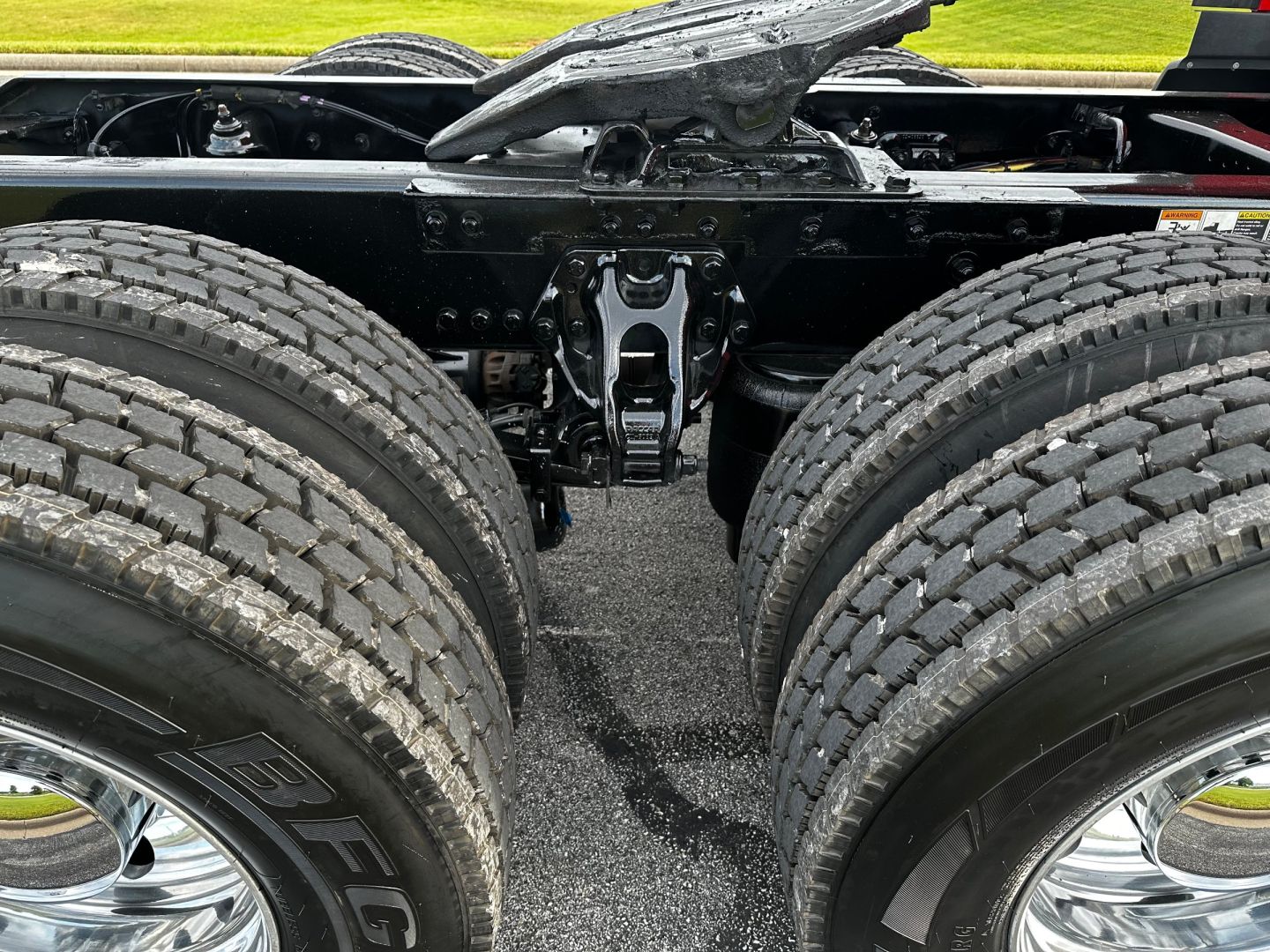 Kenworth T680 chassis with dual rear axles and suspension hangar; viewed from behind showing frame and drive components.