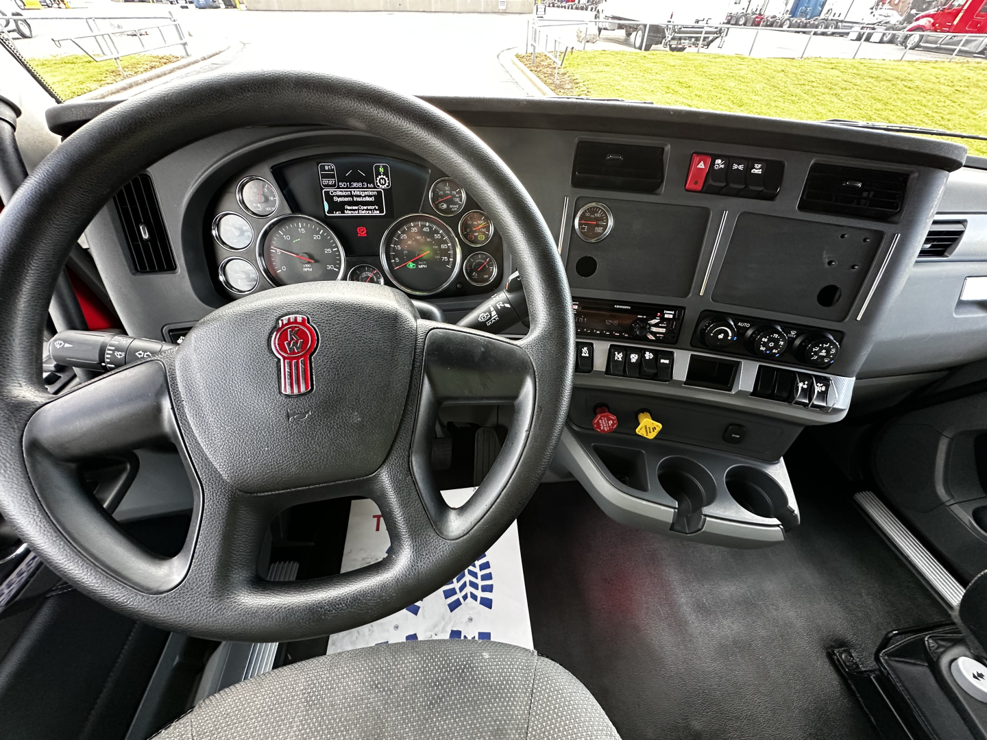 Kenworth T680 dashboard and steering wheel interior showing gauges, center console, and control panels.