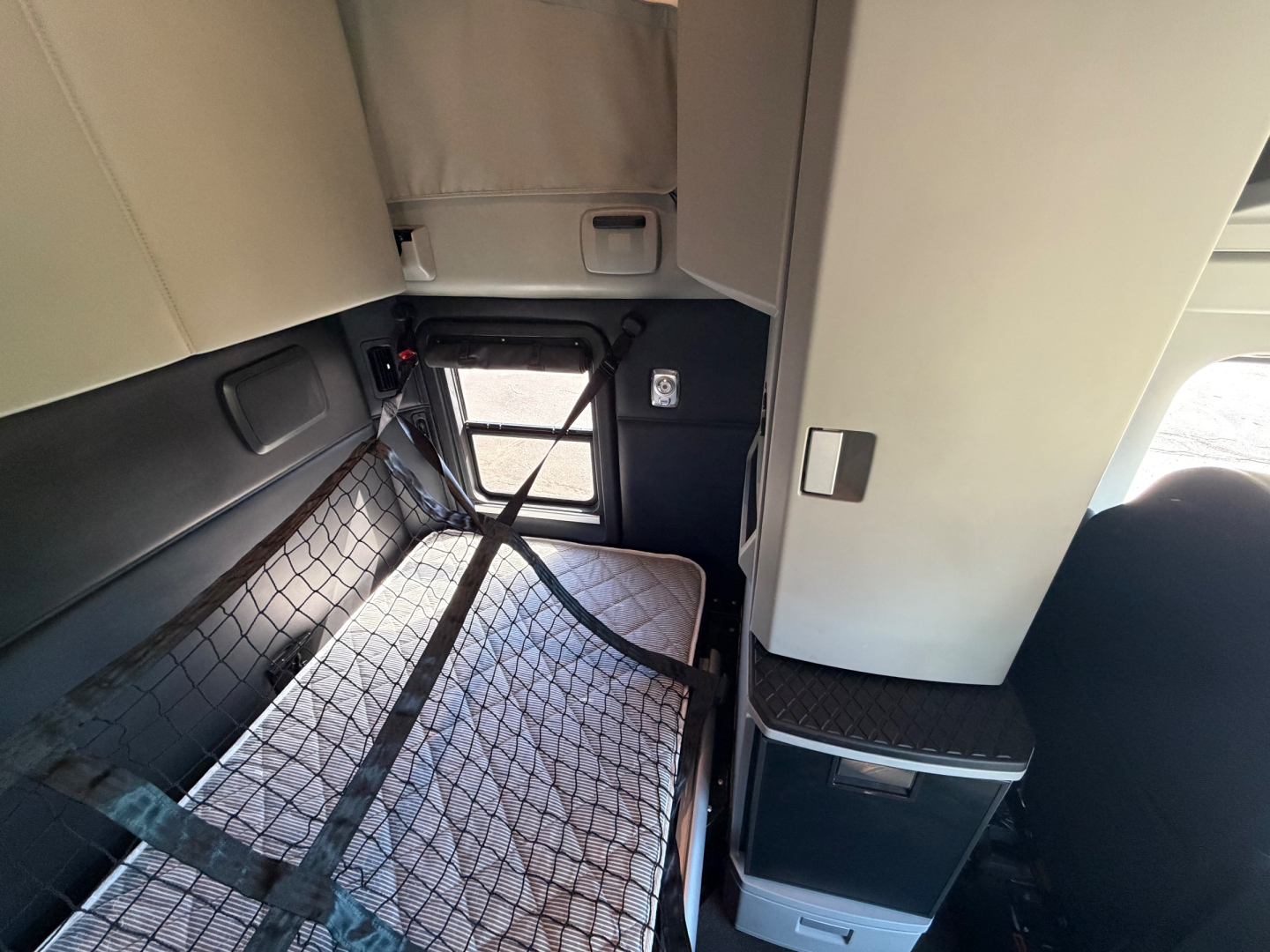 Kenworth T680 cab interior showing sleeper area with cargo net and storage compartments