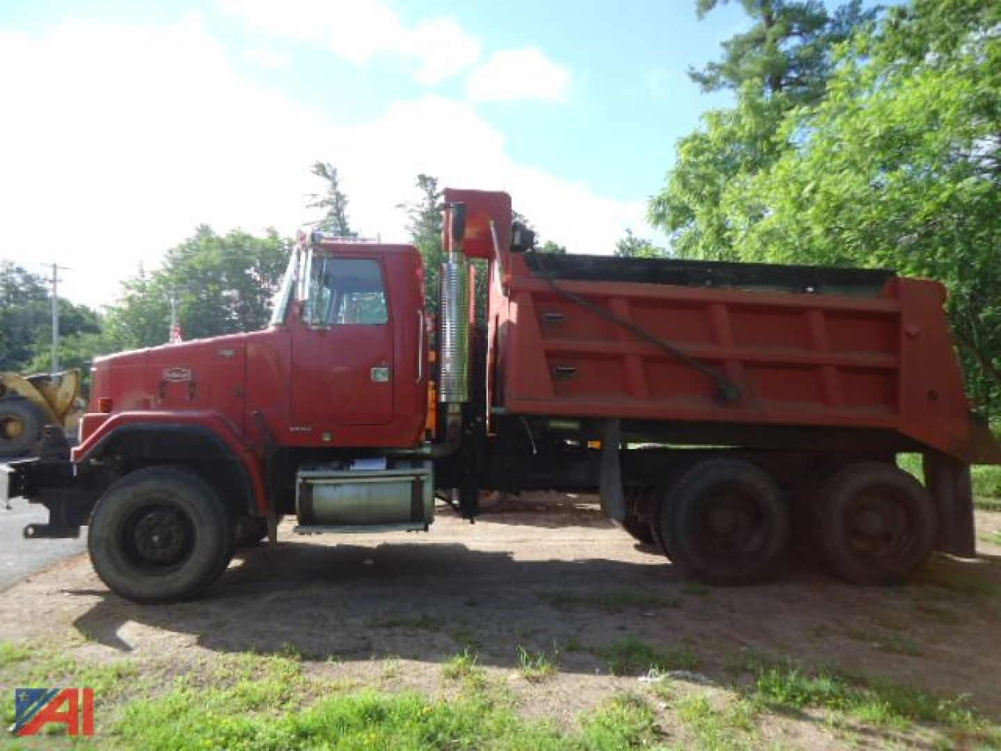Volvo ACL dump truck side view showing red dump bed and heavy chassis.