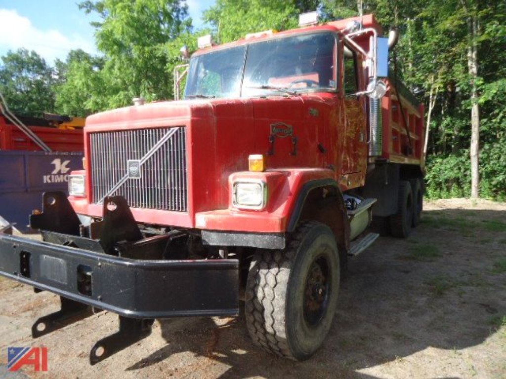 Volvo ACL dump truck front view showing large black bumper guard and red cab with Volvo emblem.