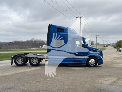 2013Peterbilt 579 side view showing sleeper cab and chassis with blue and white paint with long hood and tri-axle rear. Visible text not legible.