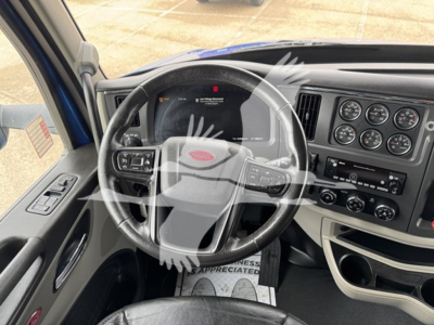 Peterbilt 579 truck interior showing steering wheel and instrument cluster with dashboard controls.