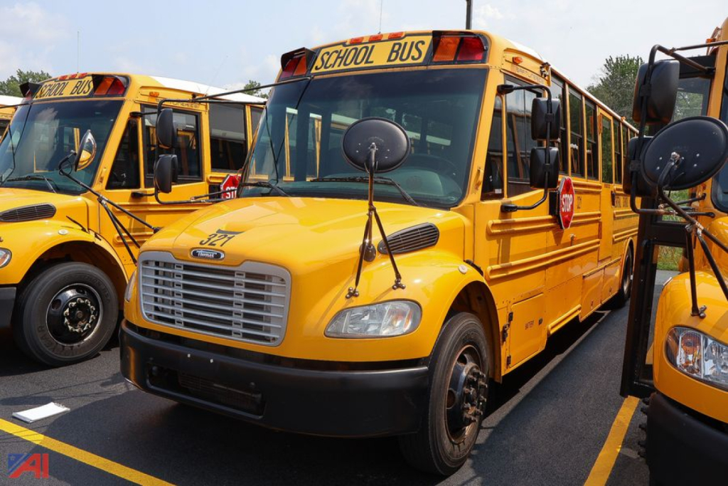 Yellow Freightliner Thomas Saf-T-Liner school bus showing front and side with school bus sign and stop sign graphic